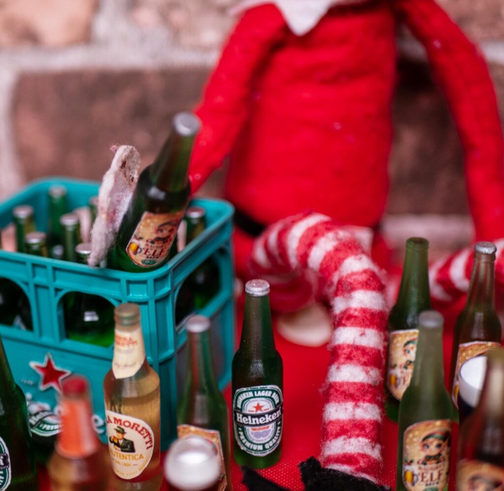 An elf with a crate of miniature bottles